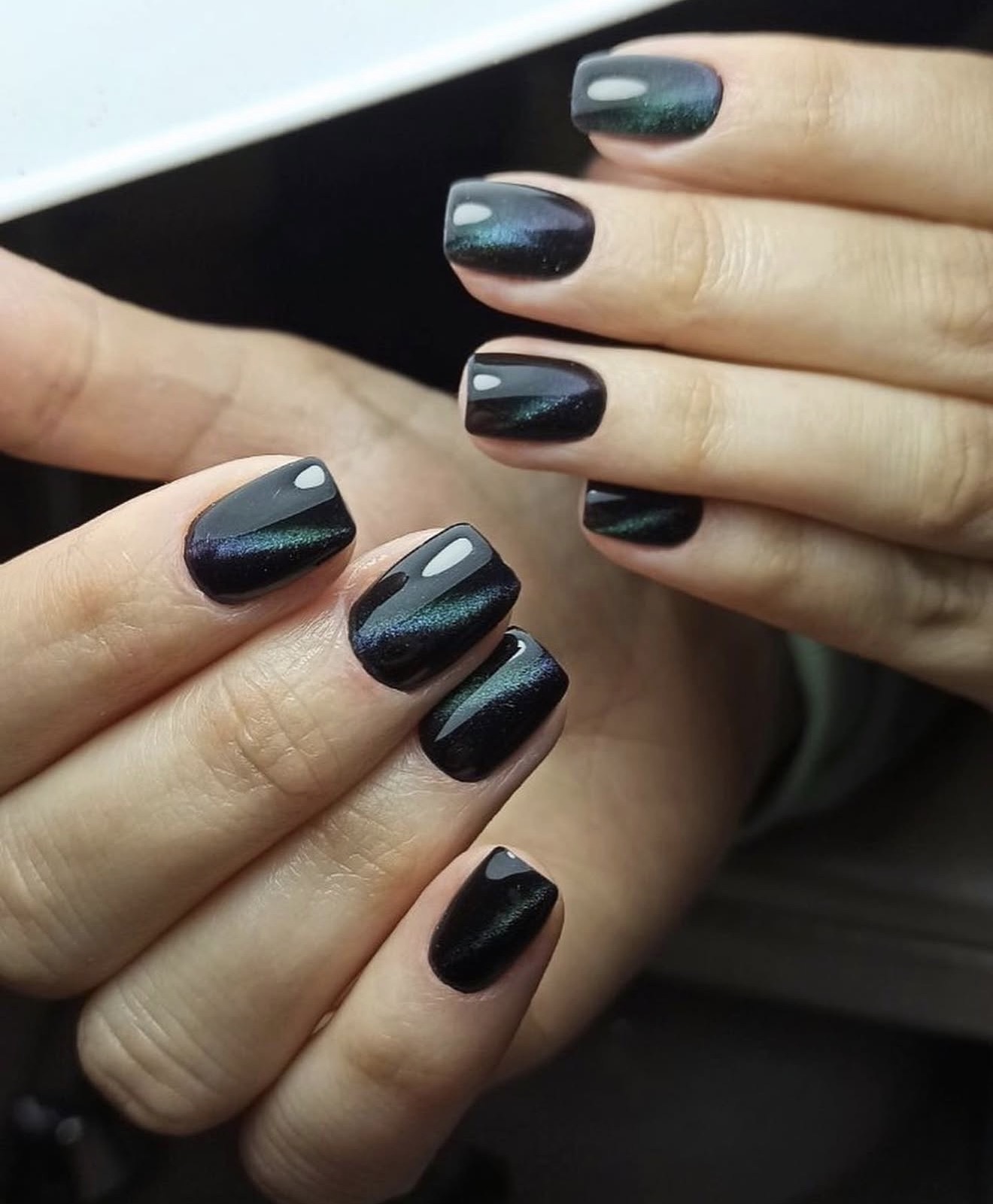 Black cat-eye magnetic gel nails with green shimmer