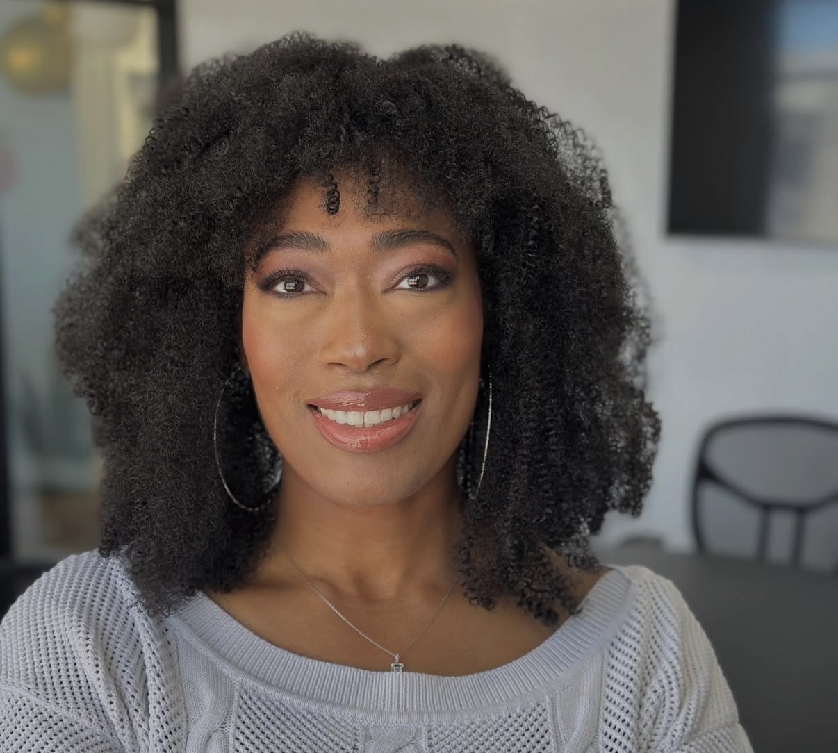 Natural curly hair styled with soft bangs and volume