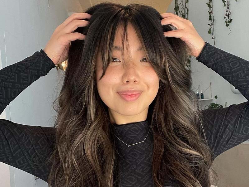 Dark brunette balayage with face-framing highlights and long layers