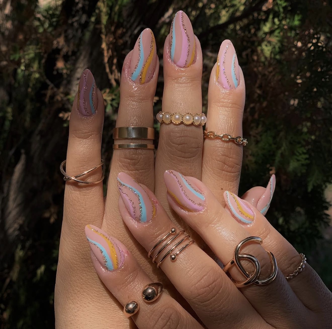 Pastel swirl almond nails with gold glitter lines