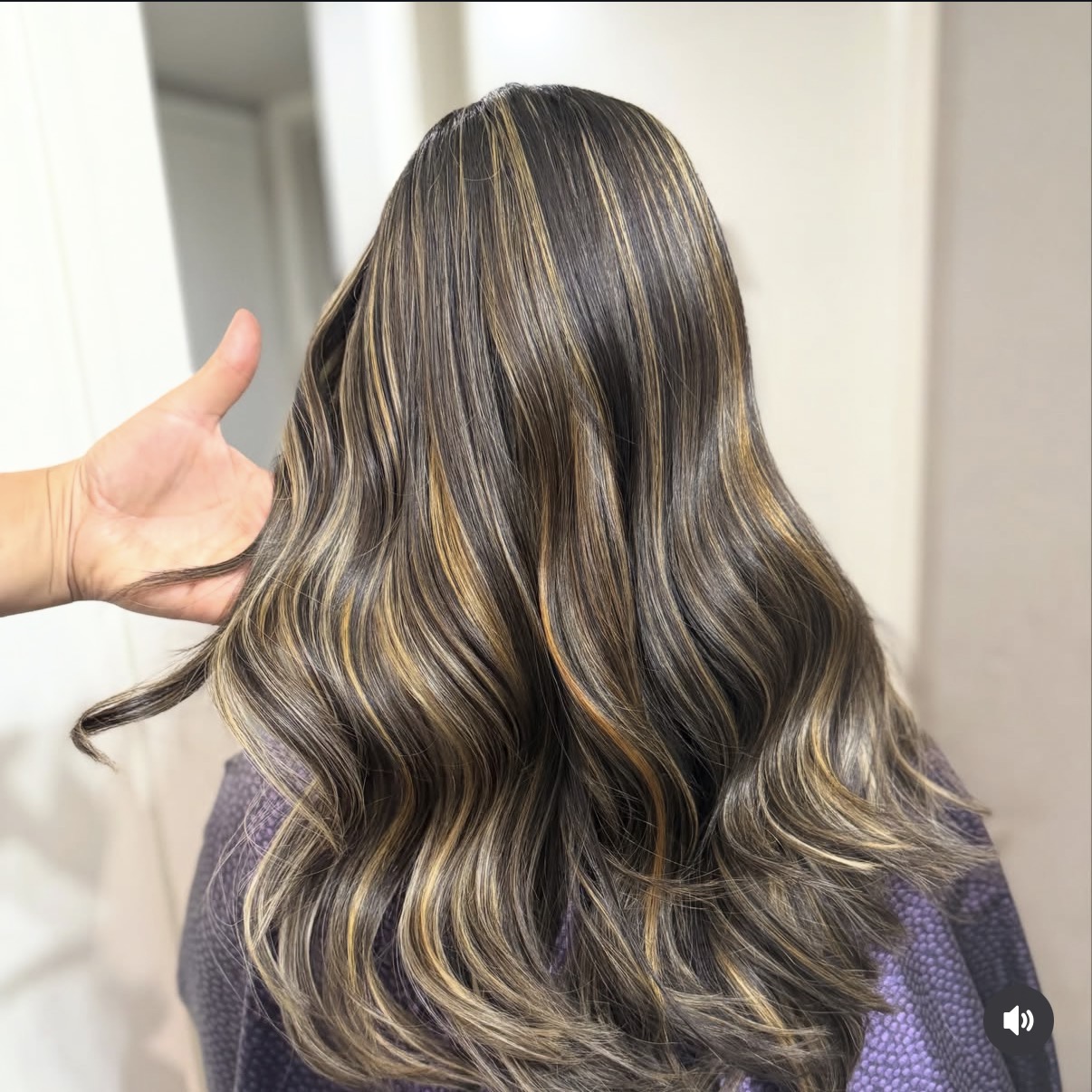 Dark brunette hair with golden ribbon highlights and glossy waves