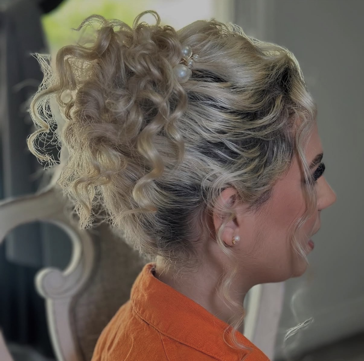 Blonde curly occasion updo with pearl hair pins